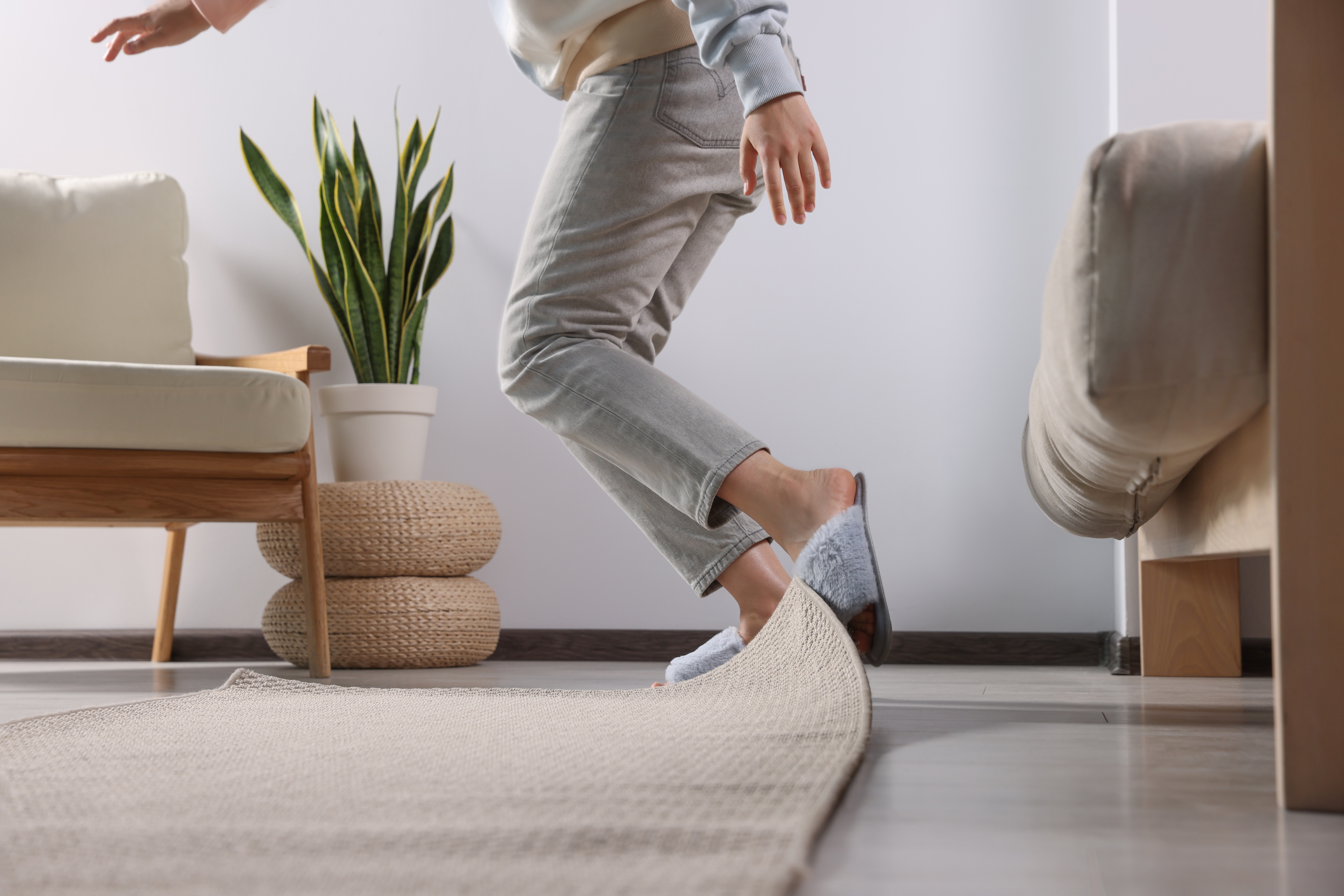 Woman tripping over a rug at home.