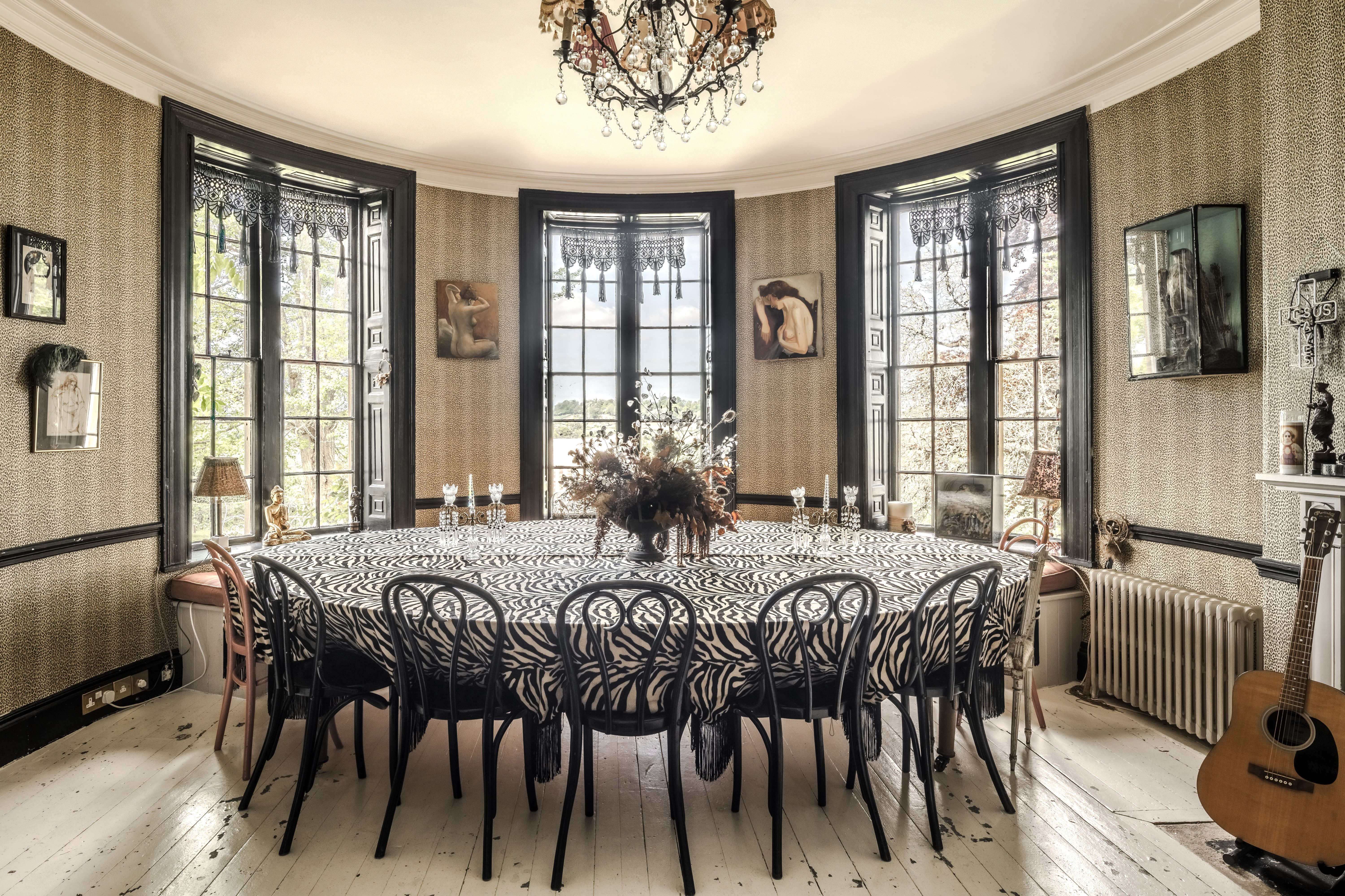 Dining room with a zebra-print tablecloth and large windows.