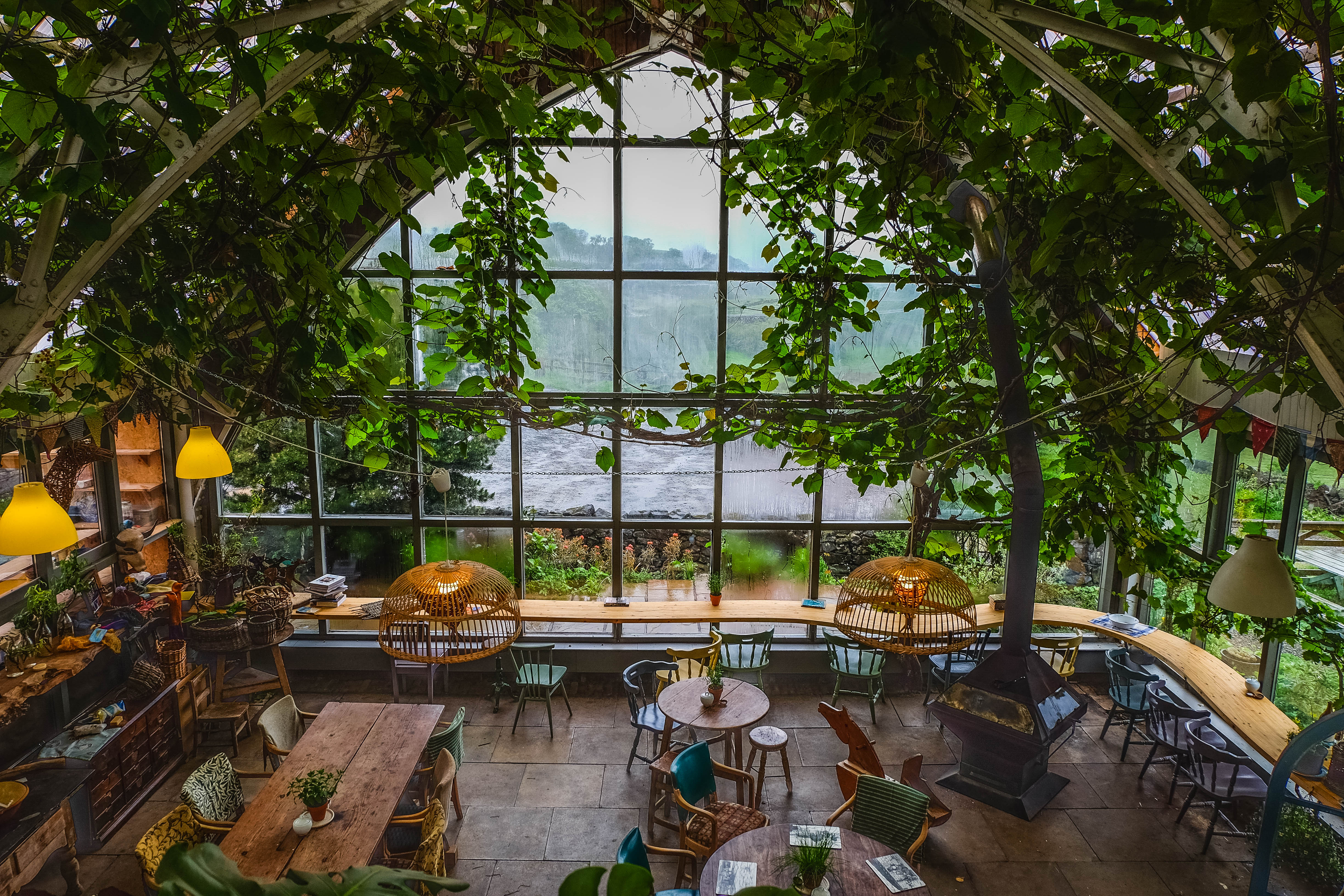 the inside of a greenhouse with tables and chairs