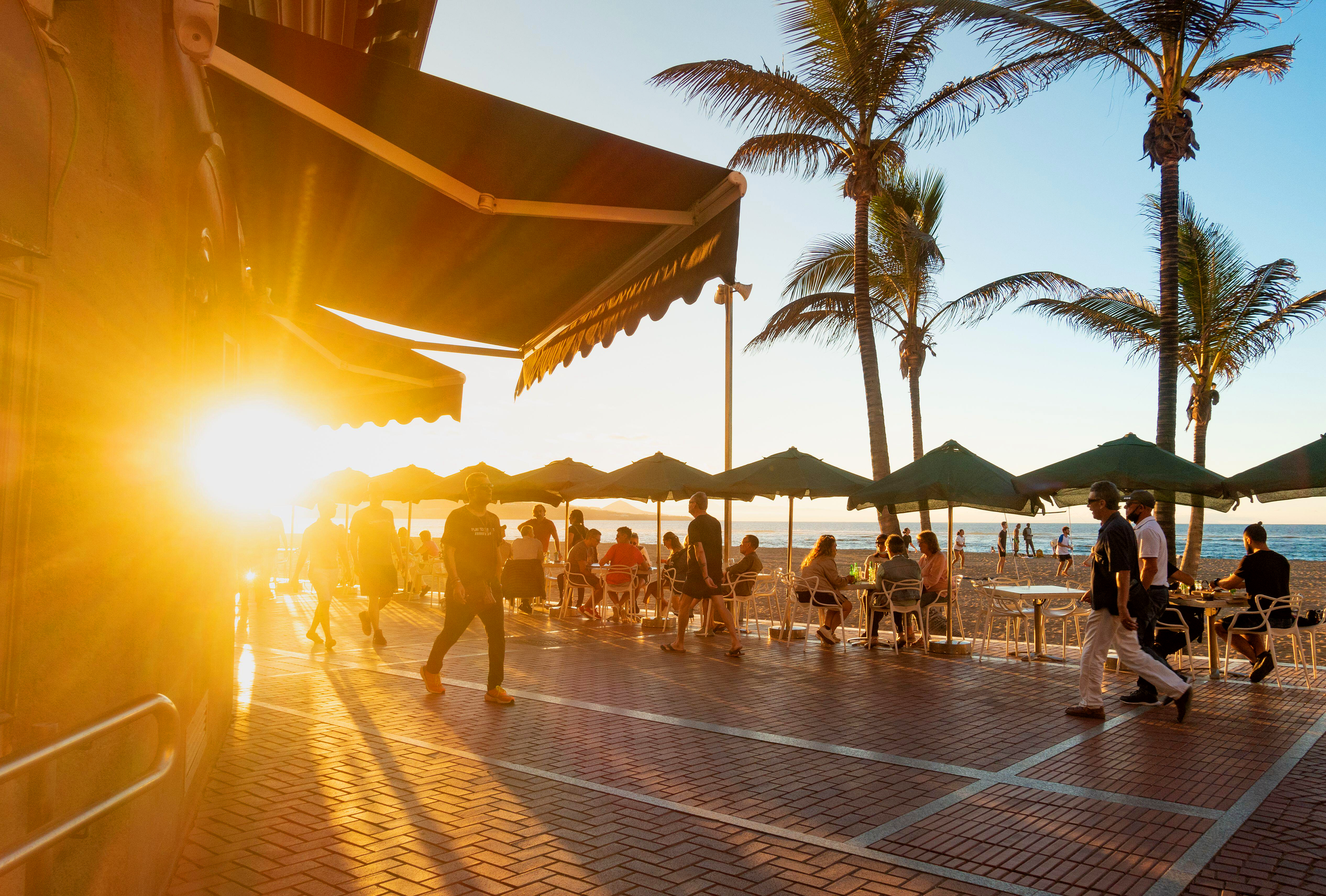 Tourists at a beach bar at sunset in Las Palmas, Gran Canaria