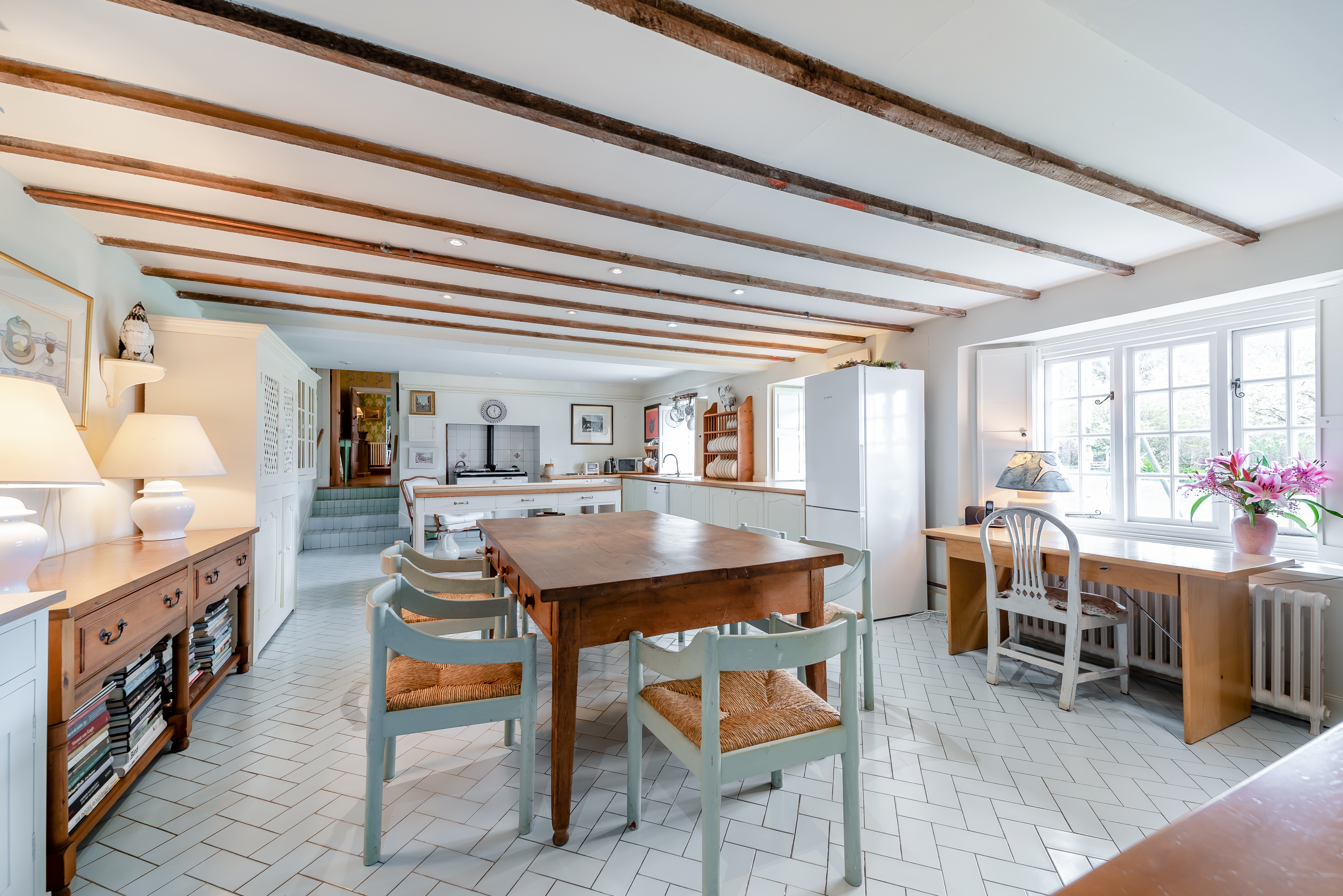 Kitchen with wooden beams and large dining table.