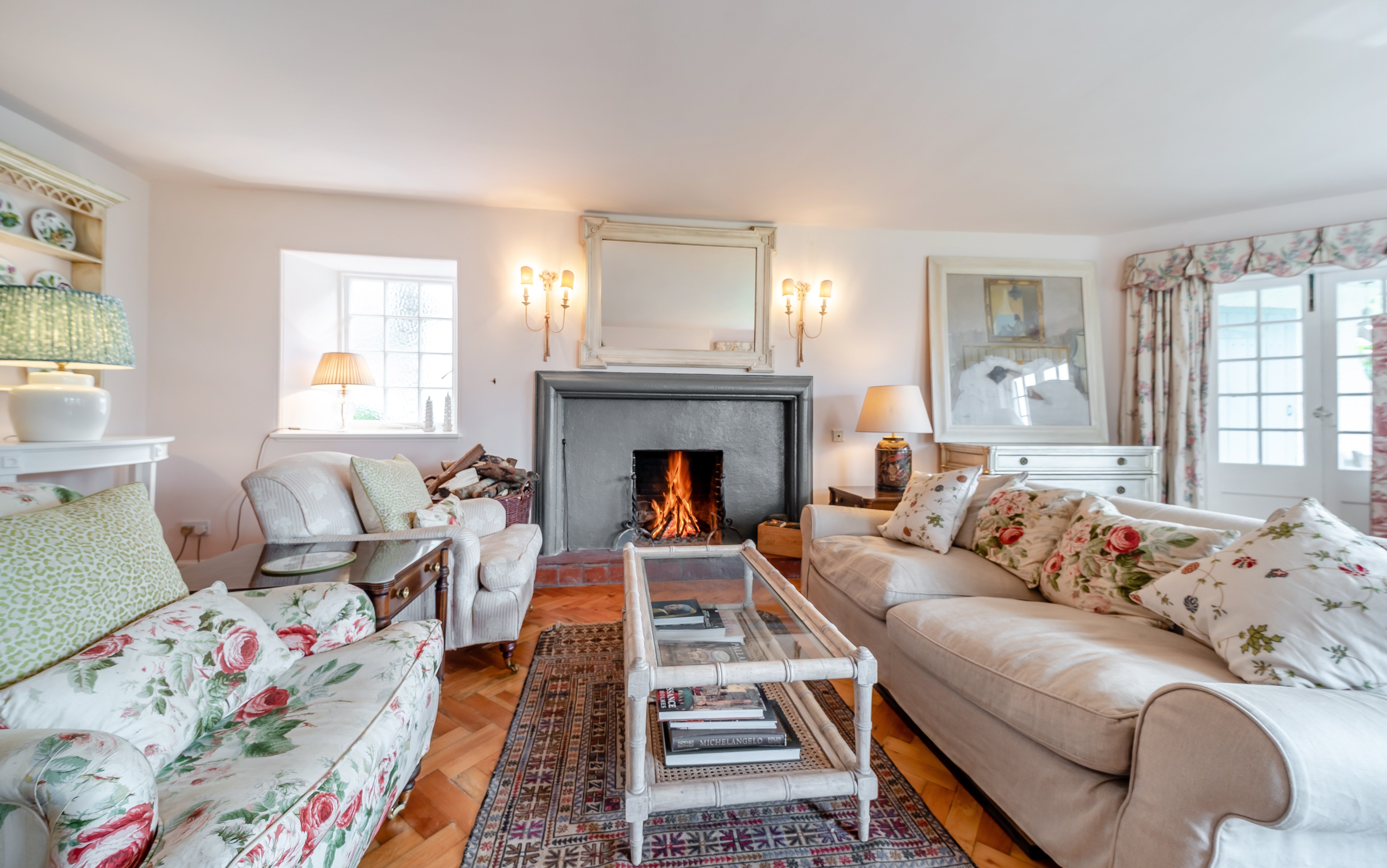 Cozy living room with a fireplace and floral sofas.