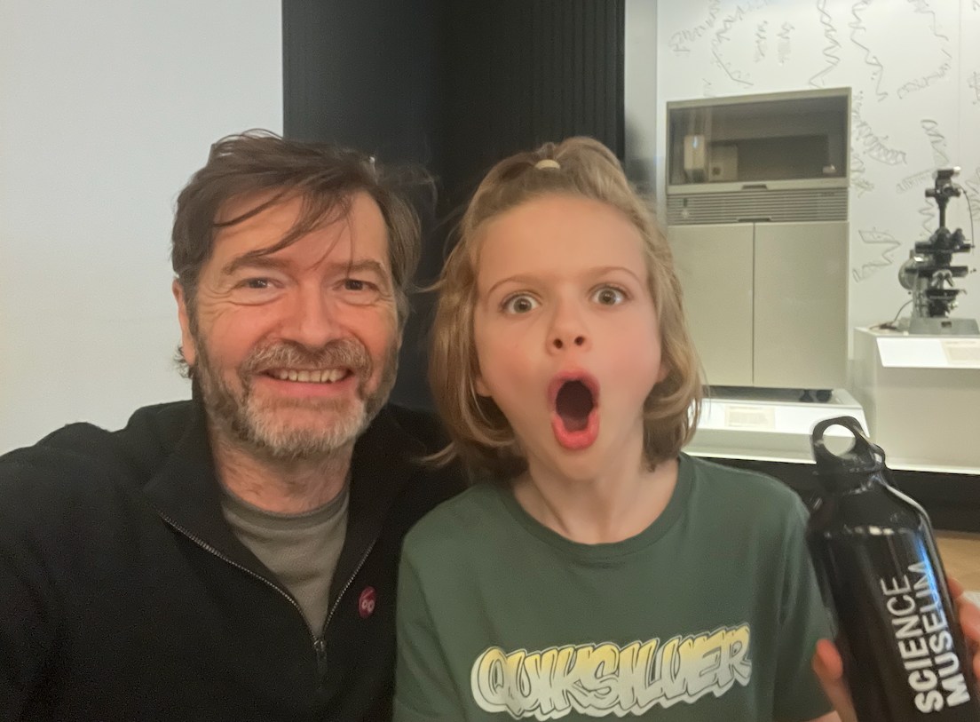 A man and child at a science museum, holding a water bottle.