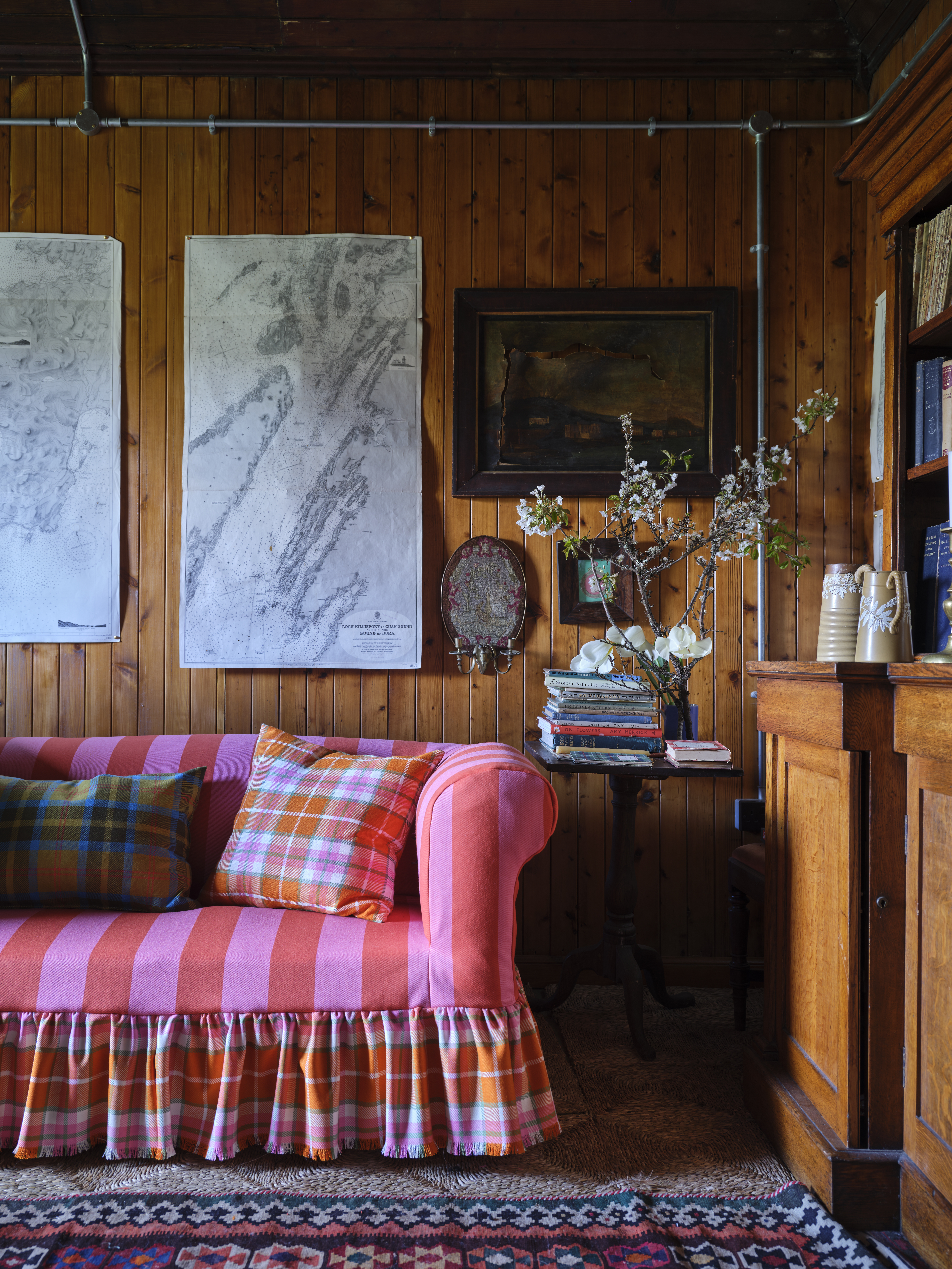 Living room with plaid sofa and nautical charts.