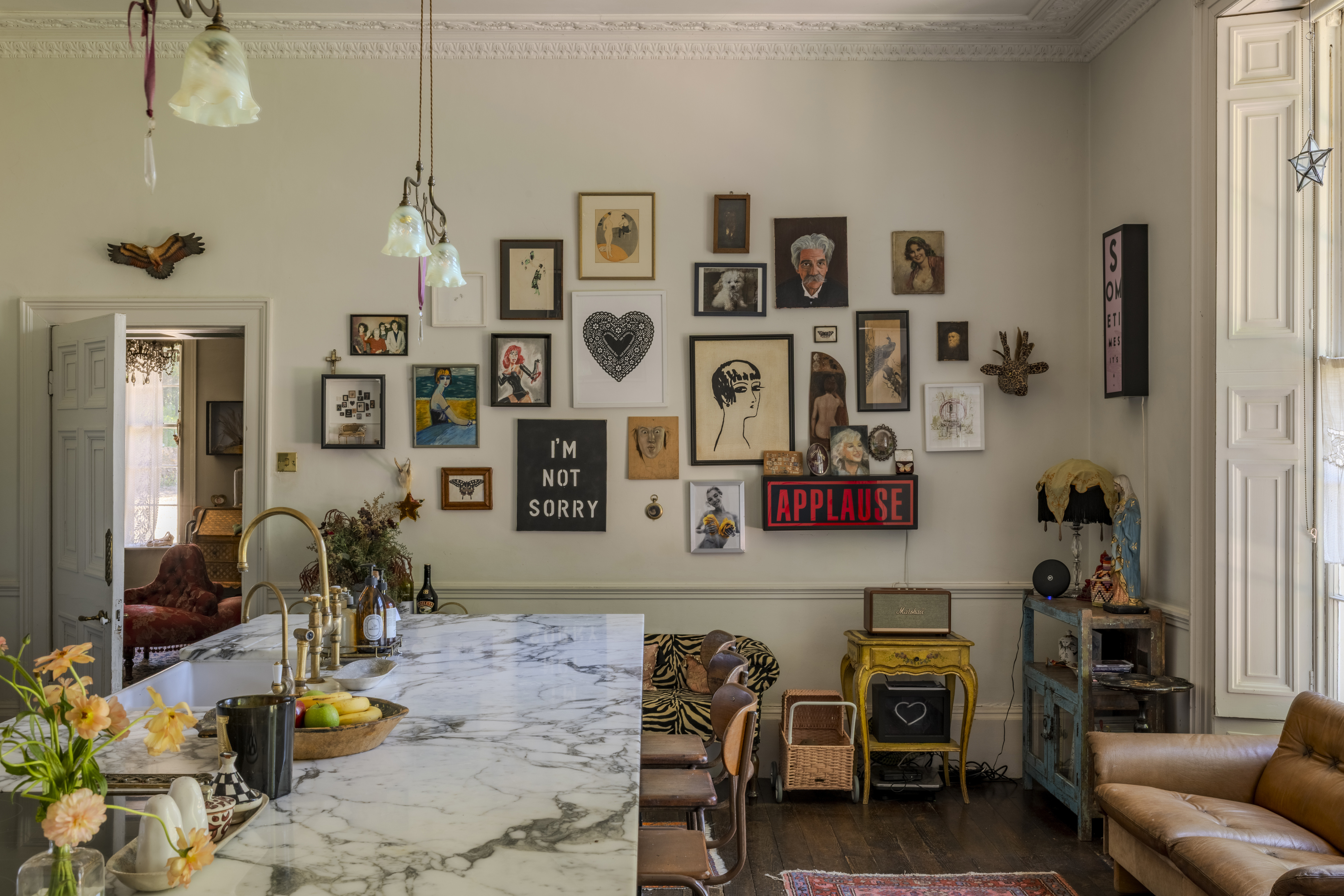 Gallery wall in a home decorated with eclectic artwork and furnishings.